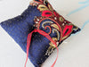 Handmade navy blue silk ring bearer pillow with intricate red and navy blue handbeading, complementing the groom's attire and coordinating seamlessly with vibrant floral bouquet colors